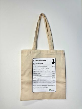 Pellavan värinen kangaskassi, jossa musta-valkoinen printti. Humoristinen printti, joka mukailee ravintoainetaulukkoa. Taulukossa lueteltuna kannuslaisen henkilön ominaisuudet huumorilla höystettynä.